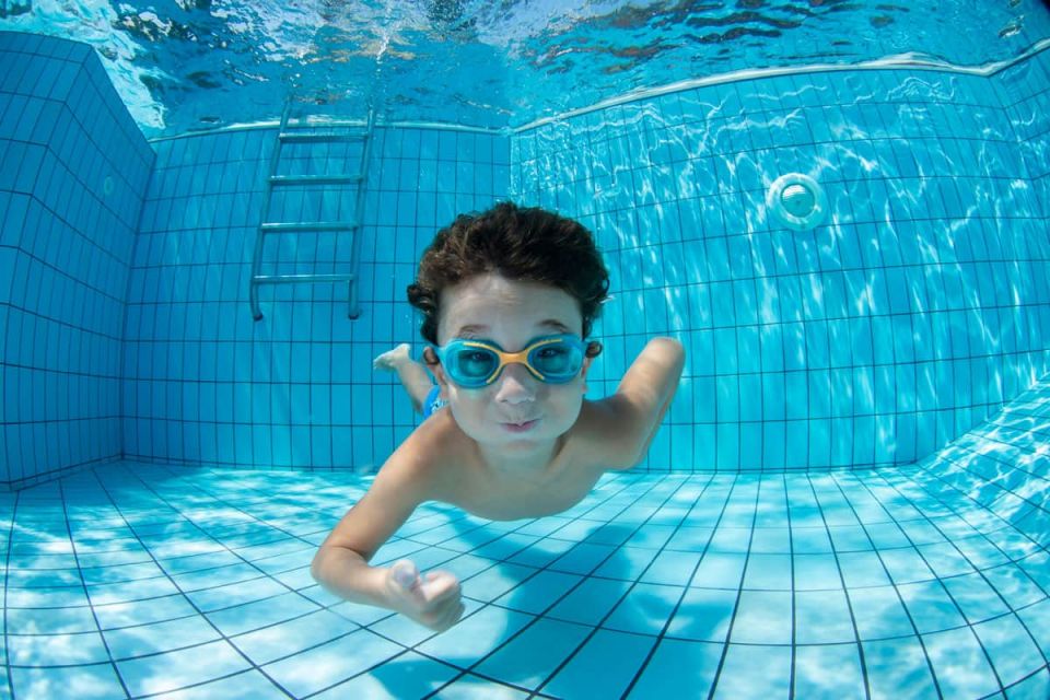 Junge taucht im Swimmingpool